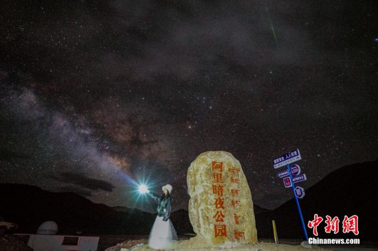 圖為6月20日晚，游客“打卡”西藏阿里暗夜公園，天上是銀河與流星（右上角）。曹枝清 攝